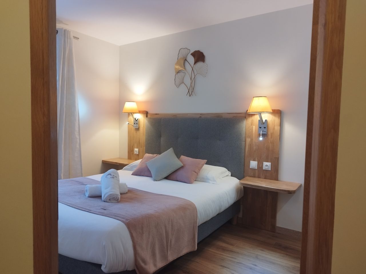 Chambre double, tête de lit capitonnée et décor ginkgo