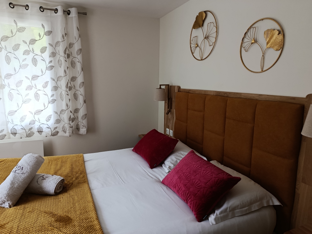 Chambre avec tête de lit velours moutarde et rideaux feuillage