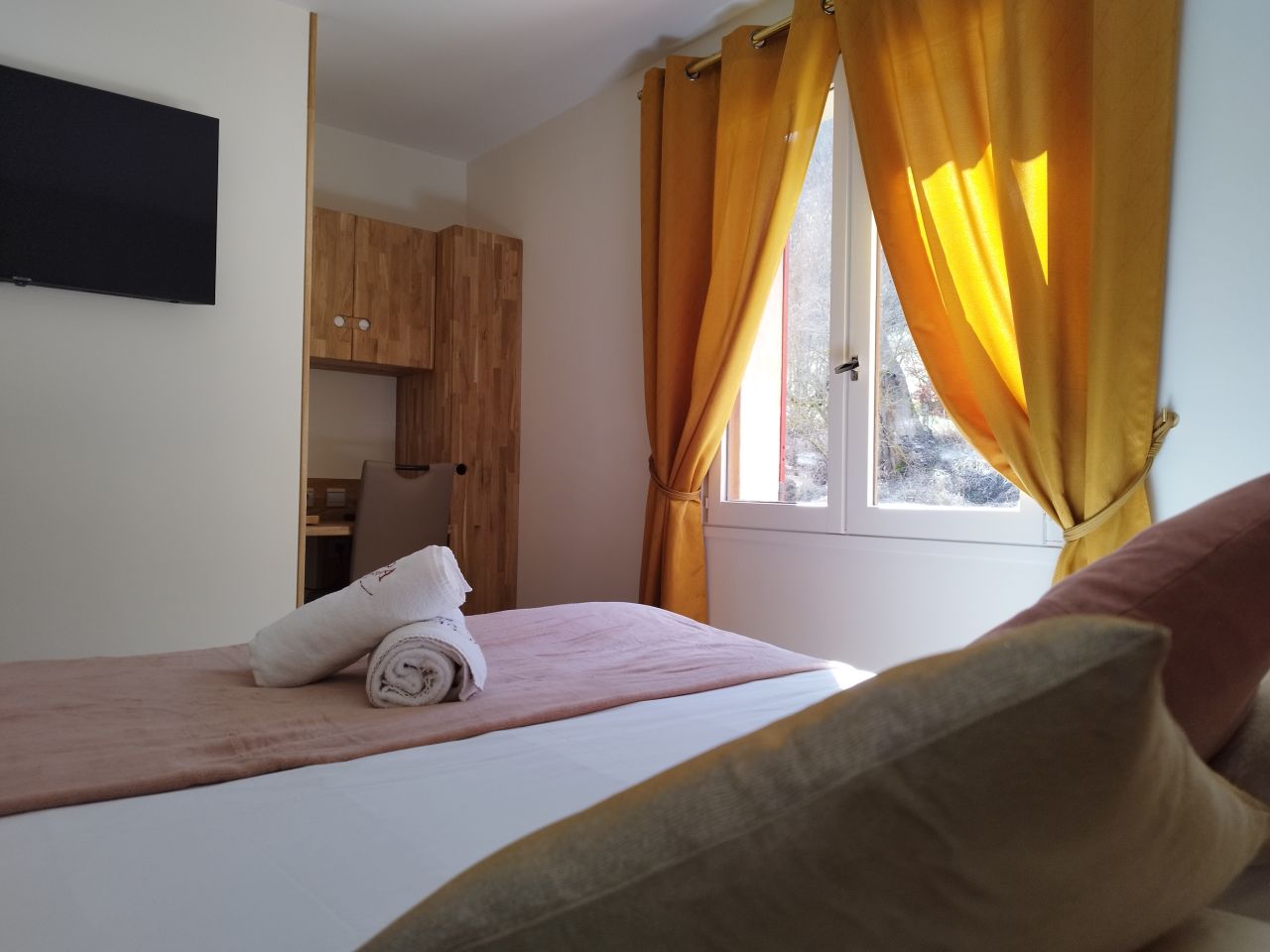 Chambre double avec vue, rideaux ocre et coin kitchenette